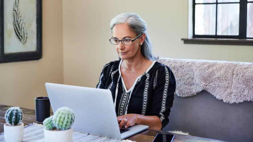 Mujer madura trabaja en su computadora portátil