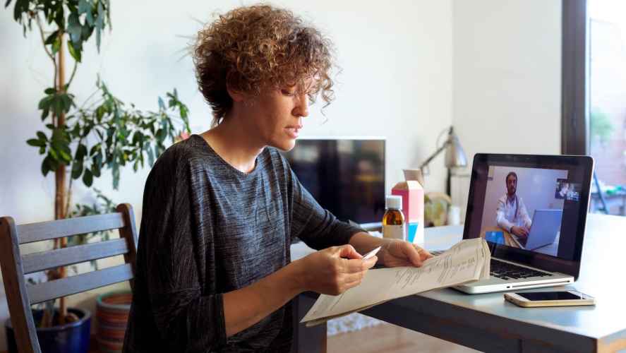 Un paciente y un médico hablan a través de sus computadoras.