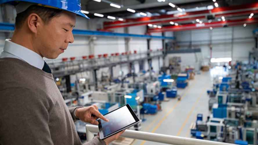 Trabajador con su tableta en la planta de fabricación